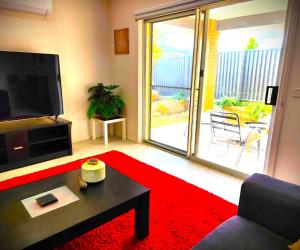 un soggiorno con TV e tappeto rosso di Lucas One 2-bedroom apartment NBN Pets a Windermere