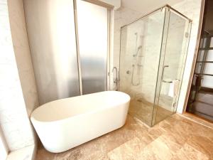 een badkamer met een wit bad en een douche bij KLCC Sky Villa Suites Platinum in Kuala Lumpur
