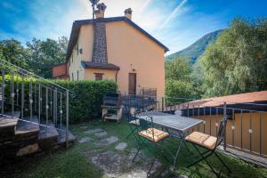 a small church with a table and chairs in front of it at Vecchia Fornace La Piastra Agriturismo, with pool, Abetone in Pian degli Ontani