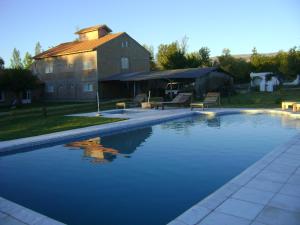 a swimming pool in front of a house at Atahualpa mi Posada in Mina Clavero