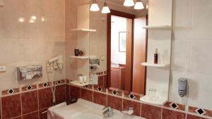 un bagno con lavandino e specchio di Rosengarten Hotel & Restaurant a Sopron