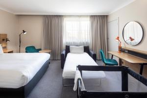 a hotel room with two beds and a mirror at Holiday Inn High Wycombe M40, Jct.4, an IHG Hotel in High Wycombe