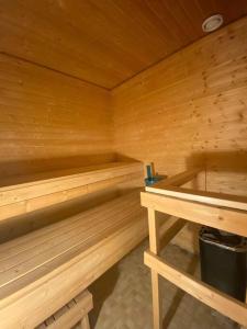 a wooden sauna with two benches and a sink at Kotimaailma - Hostel Kivikkotie in Vantaa