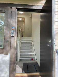 a room with a staircase with a door and a stair case at Kotimaailma - Hostel Kivikkotie in Vantaa