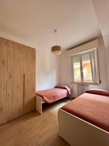 1 dormitorio con 2 camas, armario y ventana en appartamento fronte mare, en Falconara Marittima