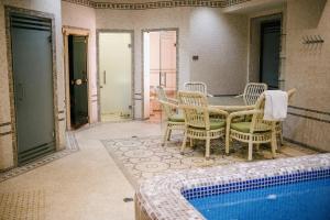 een patio met een tafel en stoelen en een zwembad bij ROYAL RESIDENCE in Tasjkent