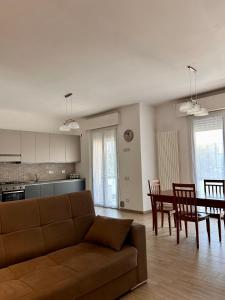 sala de estar con sofá, mesa y sillas en appartamento fronte mare en Falconara Marittima