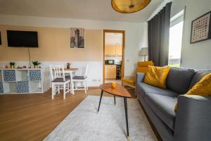 uma sala de estar com um sofá e uma mesa em FULL HOUSE Studios - KornhausPremium Apartment - Balkon, WiFi em Dessau