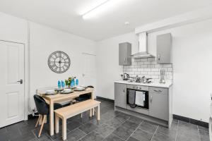 uma cozinha branca com uma mesa e um fogão em Stylish 4 Bed House in Yorkshire - Sleeps 9 em Hickleton