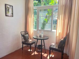 a table and two chairs in front of a window at Chiang Mai Slowtime in Chiang Mai