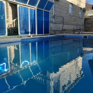 una piscina de agua azul frente a una casa en Allseasons Hotel Gabala, en Gabala