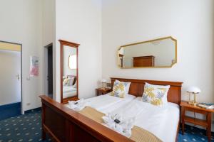 1 dormitorio con 1 cama grande y espejo en Hotel-Zimmer direkt am See, en Gmunden