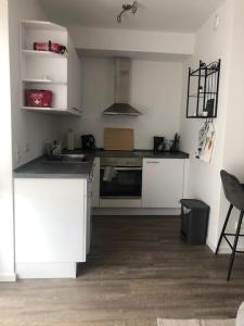 a kitchen with white cabinets and a stove top oven at Moderne Neue 2 Zimmer Wohnung in Uetersen