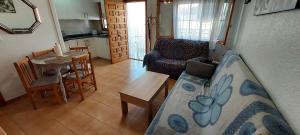 a living room with a couch and a table and a kitchen at Bungalow Fontilles 3 in Santa Pola