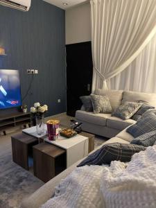a living room with a couch and a tv at شقة فاخرة (مدخل خاص - دخول ذاتي) in Riyadh