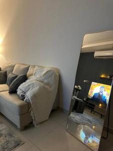 a living room with a couch and a mirror at شقة فاخرة (مدخل خاص - دخول ذاتي) in Riyadh