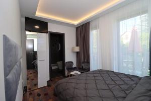 ein Hotelzimmer mit einem Bett und einem großen Fenster in der Unterkunft Prestige Miskolctapolca in Miskolc
