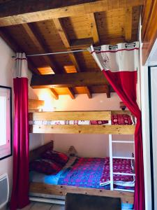 - une chambre avec 2 lits superposés et des rideaux rouges dans l'établissement Chalet Rivière du Bon Nant Location de 6 à 14 personnes en Haute Savoie, à Saint-Gervais-les-Bains