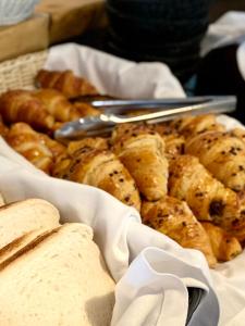 - un panier de nourriture avec du pain et des ustensiles sur une table dans l'établissement Bella Vista Hôtel, Suites & Maisons, à Porticcio