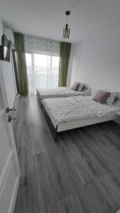 a bedroom with two beds and a wooden floor at Cazare cartier Milano in Oradea