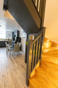 a staircase in a living room with a table and chairs at Elms Cottage in Spalding +6 photos