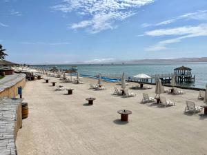 una playa con sillas y sombrillas y el océano en 501 Velas Primera Fila Vista Bahía Paracas 110 Metros - 501 T1, en Paracas