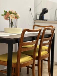 a black dining room table with yellow cushions and chairs at Atmosfera Sibiu in Sibiu +41 photos