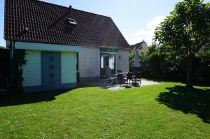 a small house with a picnic table in a yard at Kustverhuur, Park Schoneveld, Stern 233 in Breskens