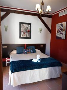 a bedroom with a bed with a blue blanket at Palacio del Gobernador in Moral de Calatrava