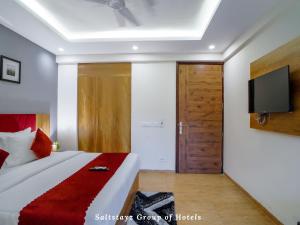 a bedroom with a bed with a television on the wall at Saltstayz Hotel Huda City Centre in Gurgaon