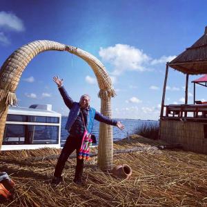 a man is standing in front of an arch at Sol del TITICACA lodge in Uros