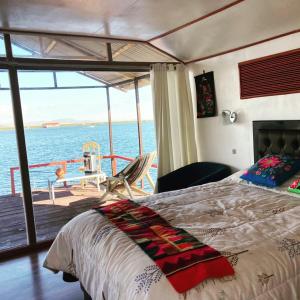 1 dormitorio con cama y vistas al océano en Sol del TITICACA lodge, en Uros