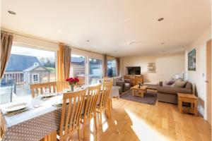 a kitchen and living room with a table and chairs at Lodge 40, Retallack Resort & Spa in Saint Columb Major