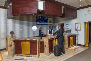 a group of people standing at a bar at Troutbeck Resort in Nyanga