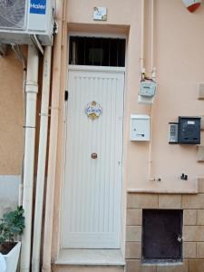 une porte blanche avec un panneau sur le bâtiment dans l'établissement La Terrazza Solarium, à Santa Flavia