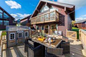 a house with a deck with a table and a building at Lodge 40, Retallack Resort & Spa in Saint Columb Major