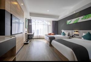 イ坊市にあるThank Inn Plus Weifang Kuiwen District Century Taihua People's Hospitalのベッド2台とデスクが備わるホテルルームです。