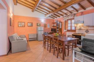 a kitchen and dining room with a table and chairs at Vecchia Fornace La Piastra Agriturismo, with pool, Abetone in Pian degli Ontani
