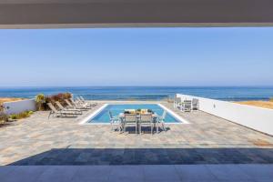 a patio with a table and chairs next to a pool at Andriana by the Sea in Pomos