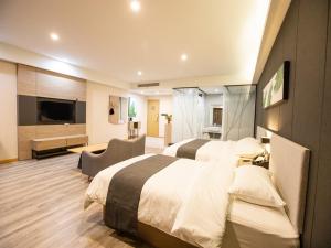 um quarto de hotel com duas camas e uma televisão em Thank Inn Plus Jining Wenshang Baoxiang Temple em Wenshang