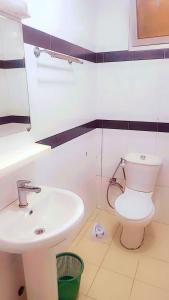 a bathroom with a white toilet and a sink at Appartement Beau Séjour in Dakar