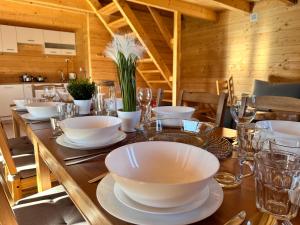 una mesa de madera con tazones y platos blancos. en Osada Karkonoska, en Kowary