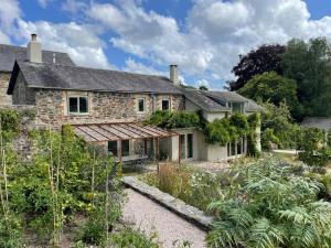 an old stone house with a garden in front of it at The Walled Garden in Totnes