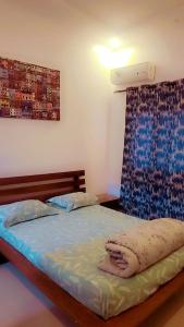 1 dormitorio con cama con sábanas azules y ventana en Appartement Beau Séjour, en Dakar