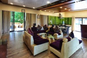 een grote woonkamer met banken en een tafel bij StayVista's Eden Bloom - Pet-Friendly Villa with Pool, Terrace & Lawn with Gazebo in Jabalpur
