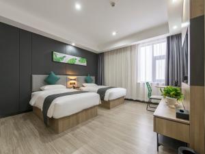 a hotel room with two beds and a television at Thank Inn Plus Jiaozuo Jiefang District Heping Street in Jiaozuo