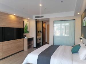 a bedroom with a large bed and a television at Thank Inn Plus Weifang Kuiwen District Century Taihua People's Hospital in Weifang