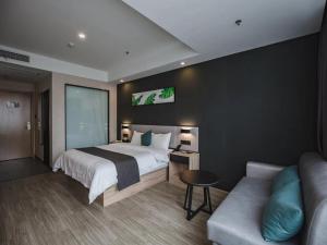 ein Hotelzimmer mit einem Bett und einem Sofa in der Unterkunft Thank Inn Plus Weifang Kuiwen District Century Taihua People's Hospital in Weifang