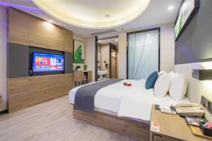 a bedroom with a large bed and a television at Thank Inn Plus Shaoguan Qujiang District Maba in Shaoguan