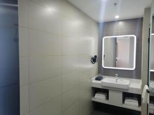 a bathroom with a sink and a mirror at Thank Inn Plus Weifang Kuiwen District Century Taihua People's Hospital in Weifang